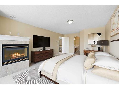 315 Rocky Ridge Drive Nw, Calgary, AB - Indoor Photo Showing Bedroom With Fireplace