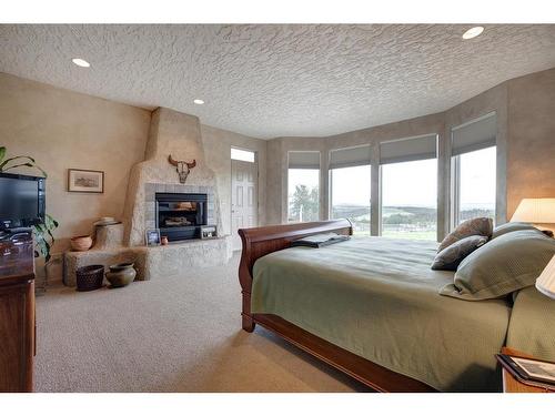 10-290254 96 Street West, Rural Foothills County, AB - Indoor Photo Showing Bedroom With Fireplace