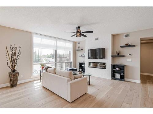 409-15 Cougar Ridge Landing Sw, Calgary, AB - Indoor Photo Showing Living Room With Fireplace