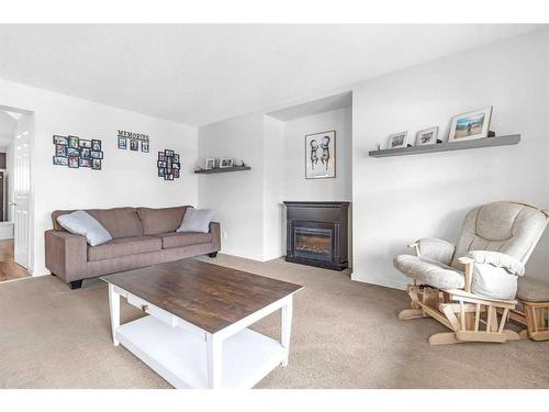 338 Sunset Common, Cochrane, AB - Indoor Photo Showing Living Room With Fireplace