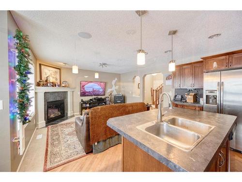 913 Cranston Drive Se, Calgary, AB - Indoor Photo Showing Kitchen With Fireplace With Double Sink
