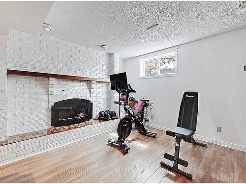 127 Silver Ridge Close Nw, Calgary, AB - Indoor Photo Showing Gym Room With Fireplace