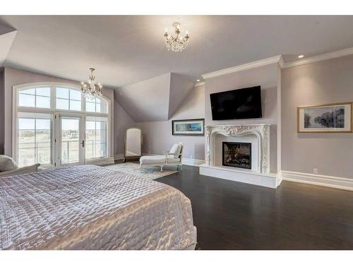 9 Swift Creek Green, Rural Rocky View County, AB - Indoor Photo Showing Bedroom With Fireplace