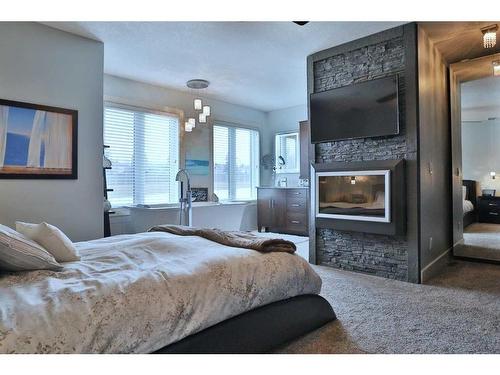 148 Hidden Circle Nw, Calgary, AB - Indoor Photo Showing Bedroom With Fireplace