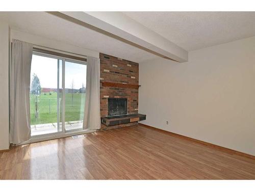 128-3219 56 Street Ne, Calgary, AB - Indoor Photo Showing Living Room With Fireplace