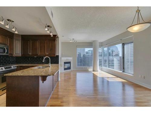 2504-910 5 Avenue Sw, Calgary, AB - Indoor Photo Showing Kitchen With Fireplace