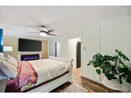 612 Meadowbrook Bay Se, Airdrie, AB - Indoor Photo Showing Bedroom With Fireplace