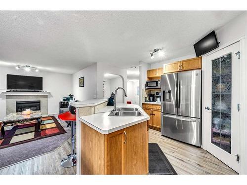 114 Saddlecrest Crescent Ne, Calgary, AB - Indoor Photo Showing Kitchen With Fireplace With Double Sink