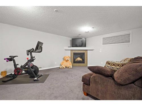 1363 New Brighton Park Se, Calgary, AB - Indoor Photo Showing Gym Room With Fireplace