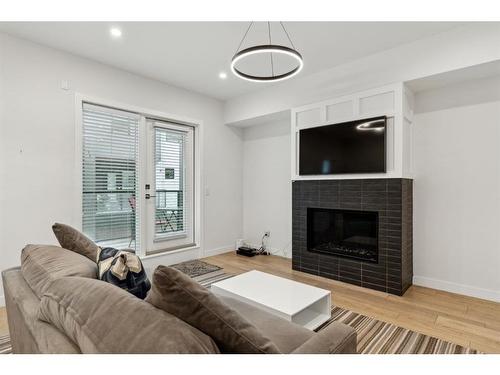 203-830 78 Street Sw, Calgary, AB - Indoor Photo Showing Living Room With Fireplace