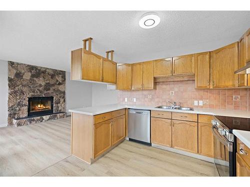 140 Sanderling Rise Nw, Calgary, AB - Indoor Photo Showing Kitchen With Fireplace With Double Sink