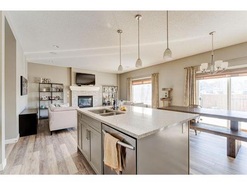 155 Kinniburgh Road, Chestermere, AB - Indoor Photo Showing Kitchen With Fireplace With Double Sink