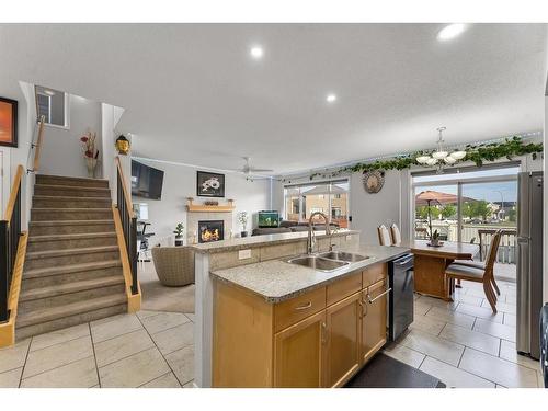 104 Saddlecrest Green Ne, Calgary, AB - Indoor Photo Showing Kitchen With Fireplace With Double Sink