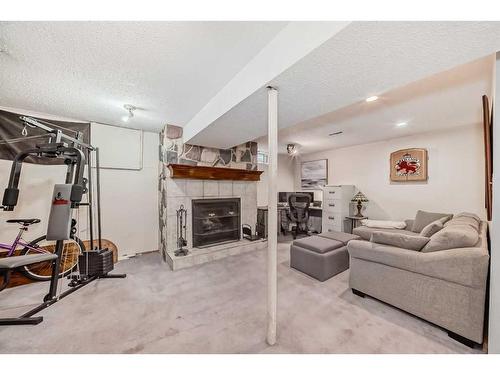 231 Penmeadows Close Se, Calgary, AB - Indoor Photo Showing Gym Room With Fireplace