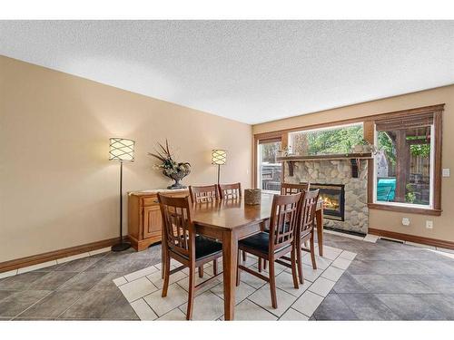 112 Hidden Ranch Close Nw, Calgary, AB - Indoor Photo Showing Dining Room With Fireplace