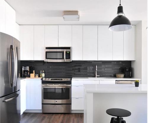 2-138 Mcrae Street, Okotoks, AB - Indoor Photo Showing Kitchen With Upgraded Kitchen