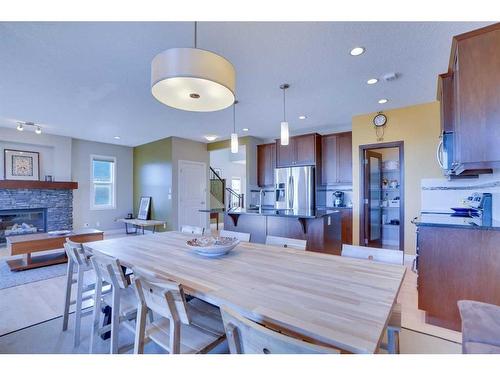 168 Heritage Boulevard, Cochrane, AB - Indoor Photo Showing Dining Room With Fireplace