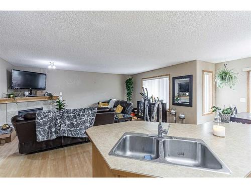 115 Panamount Heights Nw, Calgary, AB - Indoor Photo Showing Kitchen With Fireplace With Double Sink
