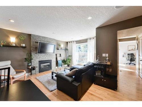 185-87 Glamis Green Sw, Calgary, AB - Indoor Photo Showing Living Room With Fireplace