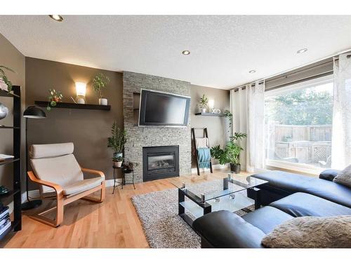 185-87 Glamis Green Sw, Calgary, AB - Indoor Photo Showing Living Room With Fireplace