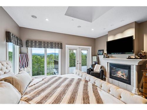 309 Wild Rose Close, Rural Rocky View County, AB - Indoor Photo Showing Bedroom With Fireplace