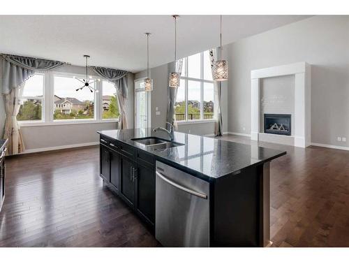 209 Kingsmere Cove Se, Airdrie, AB - Indoor Photo Showing Kitchen With Fireplace With Double Sink With Upgraded Kitchen