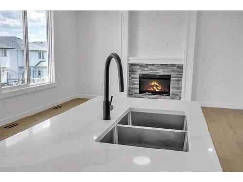 122 Baysprings Gardens, Airdrie, AB - Indoor Photo Showing Kitchen With Fireplace With Double Sink