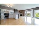 387-223 Tuscany Springs Boulevard Nw, Calgary, AB  - Indoor Photo Showing Kitchen With Fireplace 