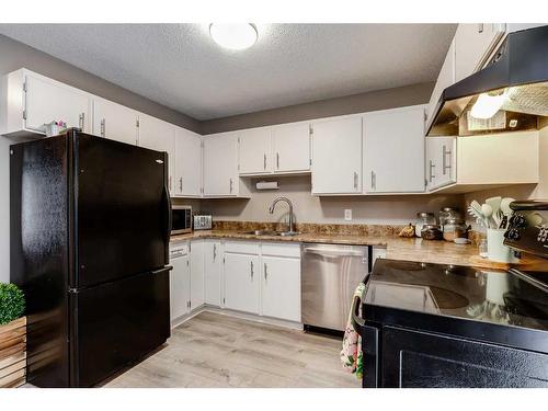 107-107 Elm Place, Okotoks, AB - Indoor Photo Showing Kitchen With Double Sink