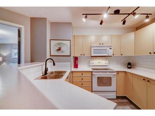 8423-304 Mackenzie Way Sw, Airdrie, AB - Indoor Photo Showing Kitchen With Double Sink