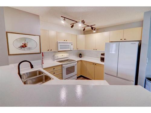 8423-304 Mackenzie Way Sw, Airdrie, AB - Indoor Photo Showing Kitchen With Double Sink