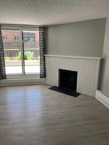 107-511 56 Avenue Sw, Calgary, AB - Indoor Photo Showing Living Room With Fireplace