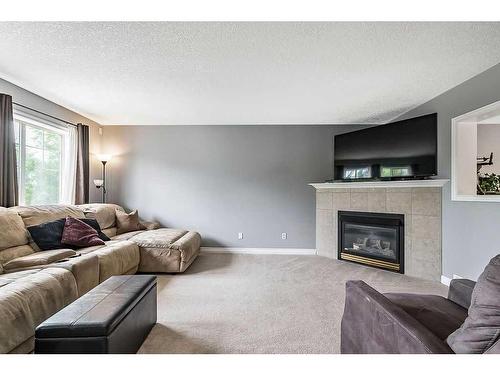 8 Crystal Shores Cove, Okotoks, AB - Indoor Photo Showing Living Room With Fireplace