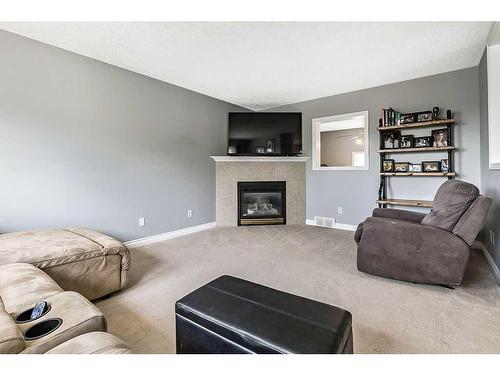 8 Crystal Shores Cove, Okotoks, AB - Indoor Photo Showing Living Room With Fireplace