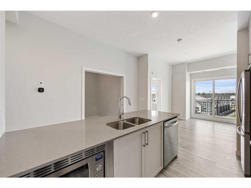 409-255 Les Jardins Park Se, Calgary, AB - Indoor Photo Showing Kitchen With Double Sink