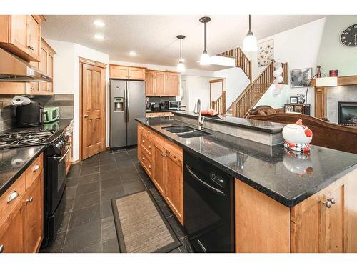 157 Cortina Bay Sw, Calgary, AB - Indoor Photo Showing Kitchen With Fireplace With Double Sink