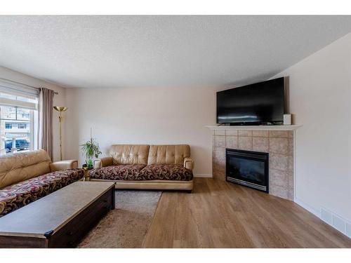 72 Crystal Shores Cove, Okotoks, AB - Indoor Photo Showing Living Room With Fireplace