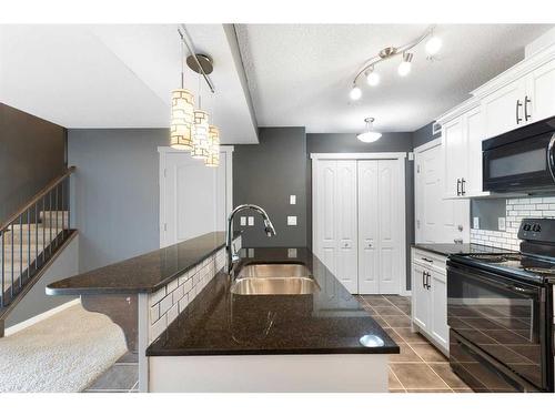 312-141 Mountain Street, Cochrane, AB - Indoor Photo Showing Kitchen With Double Sink