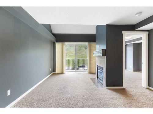 312-141 Mountain Street, Cochrane, AB - Indoor Photo Showing Other Room With Fireplace