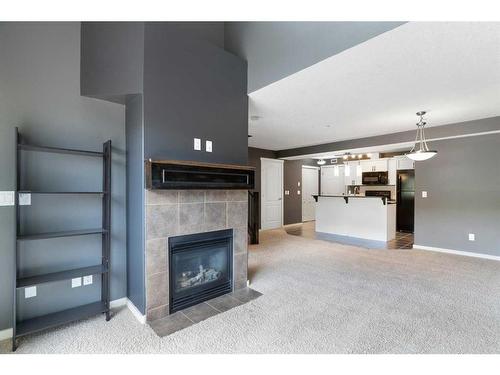 312-141 Mountain Street, Cochrane, AB - Indoor Photo Showing Living Room With Fireplace