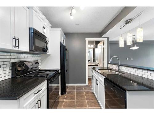 312-141 Mountain Street, Cochrane, AB - Indoor Photo Showing Kitchen With Double Sink