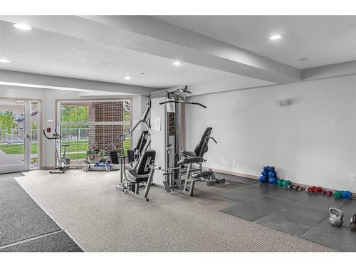 208-1 Crystal Green, Okotoks, AB - Indoor Photo Showing Gym Room