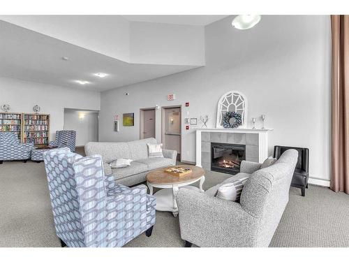 208-1 Crystal Green, Okotoks, AB - Indoor Photo Showing Living Room With Fireplace