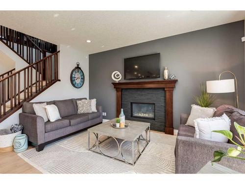 1177 Coopers Drive Sw, Airdrie, AB - Indoor Photo Showing Living Room With Fireplace