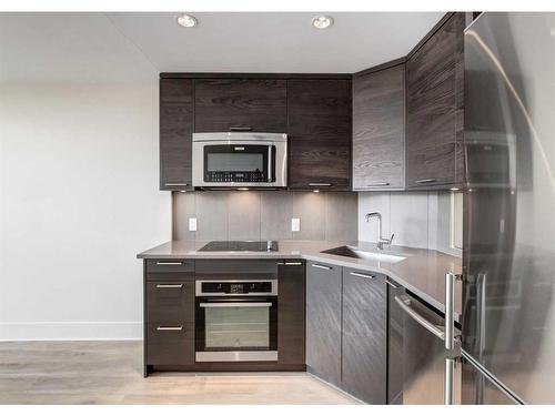 317-1087 2 Avenue Nw, Calgary, AB - Indoor Photo Showing Kitchen With Upgraded Kitchen