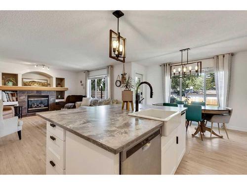 121 Crystal Shores Grove, Okotoks, AB - Indoor Photo Showing Kitchen With Fireplace