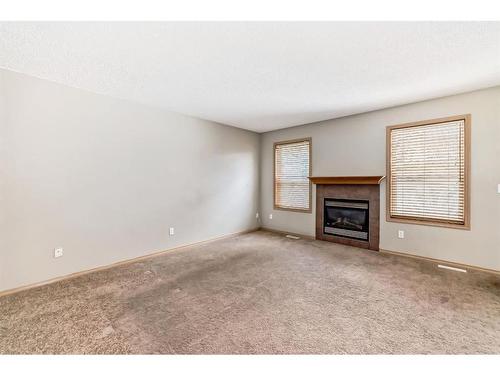 355 Eversyde Boulevard Sw, Calgary, AB - Indoor Photo Showing Other Room With Fireplace