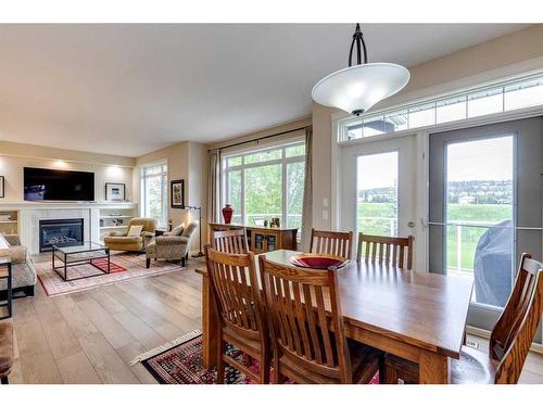 18 Discovery Woods Villas Sw, Calgary, AB - Indoor Photo Showing Dining Room With Fireplace