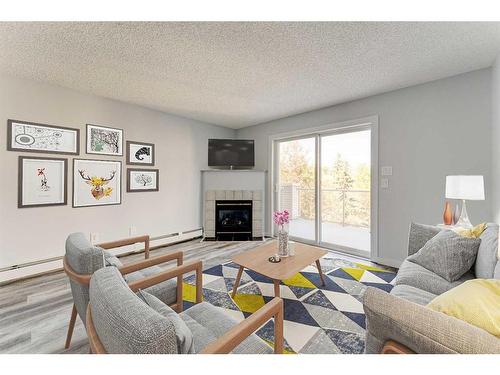 403-6000 Somervale Court Sw, Calgary, AB - Indoor Photo Showing Living Room With Fireplace