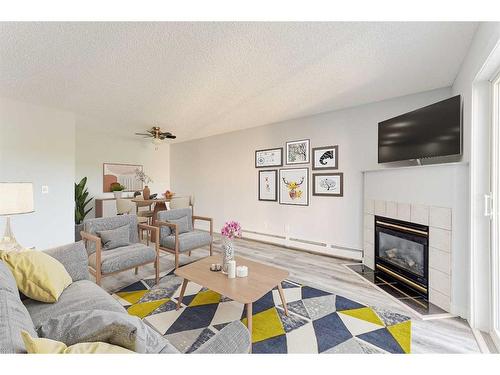 403-6000 Somervale Court Sw, Calgary, AB - Indoor Photo Showing Living Room With Fireplace